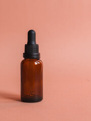 Different serum cosmetic bottles, white and dark brown dropper bottle container and packaging skincare product. studio pastel light background.