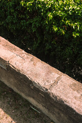 Stone bench in park with green foliage. Minimal outdoor scene for product presentation, website, or social media.