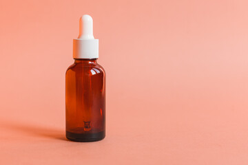 Different serum cosmetic bottles, white and dark brown dropper bottle container and packaging skincare product. studio pastel light background.