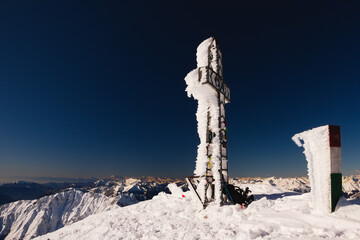 Frozen cross on the top of mount  Pizzo Arera, a famous mountaineering destination in the Orobie Alps, Lombardy, Italy