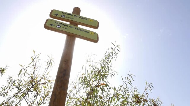 Wooden signpost for hikers indicating the routes towards Casilla del Agua and Collado de Volaores.