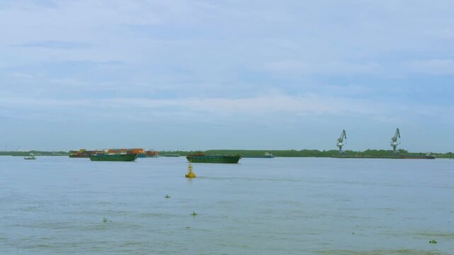 Sand Carrier and Bulk Barge Transporting Materials in Vietnam
heavy-load bulk carrier (sand barge) travels slowly across the grey water, transporting raw construction materials.