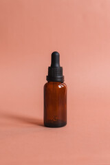 Different serum cosmetic bottles, white and dark brown dropper bottle container and packaging skincare product. studio pastel light background.