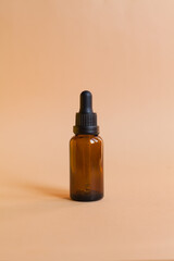 Different serum cosmetic bottles, white and dark brown dropper bottle container and packaging skincare product. studio pastel light background.