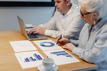 Business Meeting with Statistical Charts and Laptop