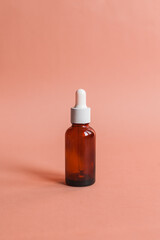 Different serum cosmetic bottles, white and dark brown dropper bottle container and packaging skincare product. studio pastel light background.