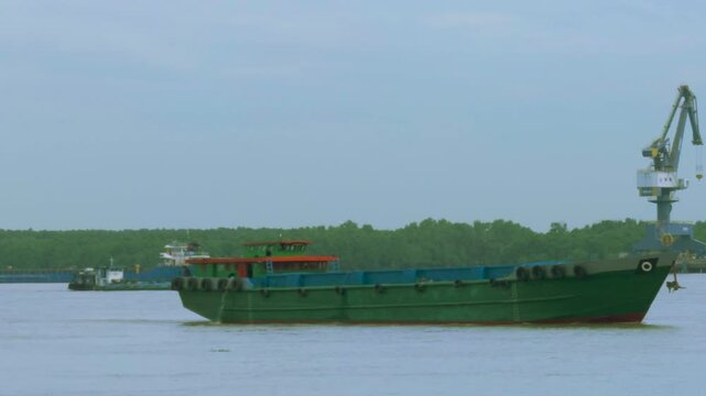 Sand Carrier and Bulk Barge Transporting Materials in Vietnam
heavy-load bulk carrier (sand barge) travels slowly across the grey water, transporting raw construction materials.
