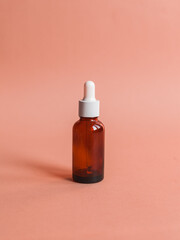 Different serum cosmetic bottles, white and dark brown dropper bottle container and packaging skincare product. studio pastel light background.