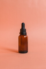 Different serum cosmetic bottles, white and dark brown dropper bottle container and packaging skincare product. studio pastel light background.