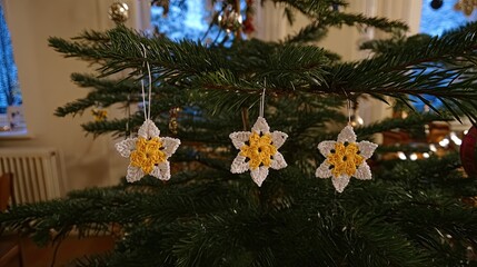 three white snowflake-shaped ornaments with yellow crocheted stars hanging on the christmas tree