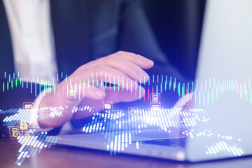 Person using laptop with graphs and icons on screen during a business meeting in an office setting