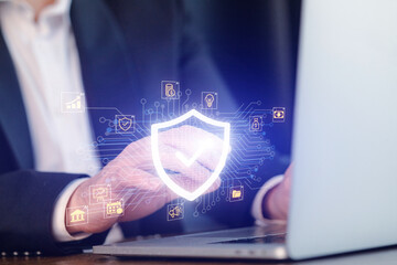 Businessperson uses technology for cybersecurity while working on a laptop in an office setting during daytime