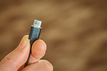 Close-up of a hand holding a USB Type-C cable.
