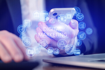 Focus on digital marketing while using a smartphone and working on a laptop in a modern office setting