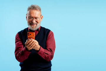Senior man happily experiencing mobile technology, enjoying smartphone app or message