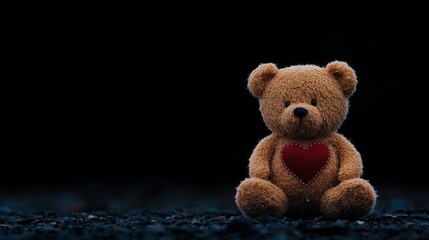 Soft teddy bear with a red heart on a dark background, symbolizing love and warmth