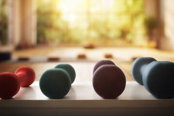 Neoprene dumbbells of different weights and colors on white table