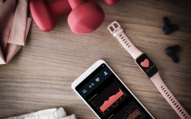 Digital training monitor with women's sports accessories on wooden table