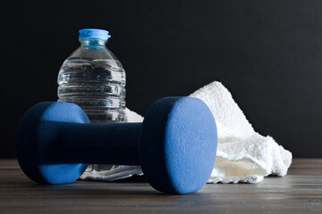 Sport training with dumbbells water and towel black isolated background