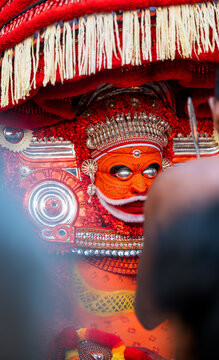 Kannur, Kerala / India &ndash; December 12, 2025: A Theyyam performer dressed in traditional red ritual costume holds a flaming torch during a Theyyam ritual performance at a temple in Kannur district