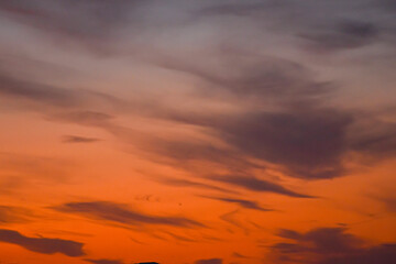 Fototapeta premium Atmospheric sunset sky painted with dramatic hues and gentle clouds