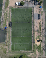 Cenital con dron de campo de f&uacute;tbol dividido en tres canchas menosres para pr&aacute;cticas o f&uacute;tbol infantil