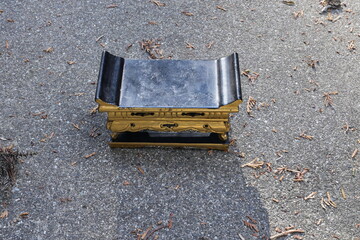 A black and gold bench is sitting on a concrete surface. The bench is empty and he is old