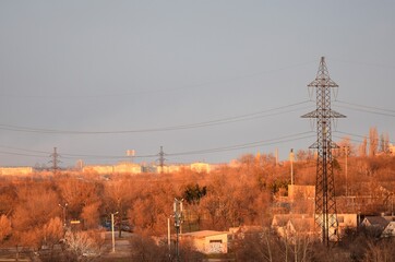 Power line on a background of the city at sunset