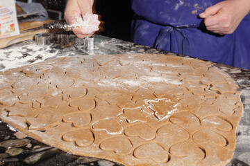 Sprinkling flour over gingerbread dough for Christmas cookies