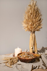 Christmas Eve celebration in Ukraine. Diduh, traditional Christmas decor, kutia, ritual food made from wheat, poppy seeds and raisins, candle light on neutral linen cloth, empty wall background