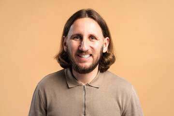 Fototapeta premium Smiling man with long hair and beard posing in a studio headshot
