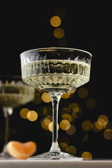Close-up of champagne glass with golden bokeh and elegant tone