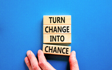 Turn change into chance symbol. Concept words phrase Turn change into chance on beautiful wooden blocks. Beautiful blue paper background. Business Turn change into chance concept. Copy space.