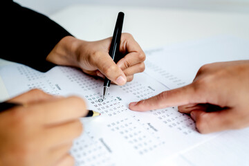 Close up of business people marking dates on calendar with pen and finger, planning schedule,...