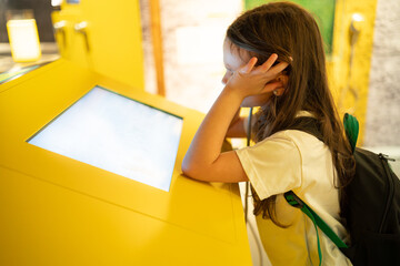 Girl resting head on hand looking at museum exhibit, childhood curiosity and education concept