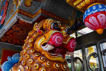 A brightly colored lion statue on the facade of the Sri Maha Mariamman Temple in Bangkok, Thailand