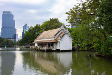 Obraz premium House with a tiled roof on stilts on the water in Lumpini Park in Bangkok, Thailand