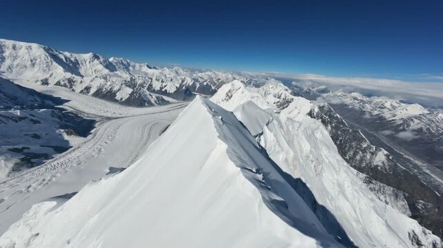 Snow cornices and rocky slopes of Chapaev Peak FPV-drone dive. Tian Shan mountains, awesome landscape on Kyrgyzstan. 4K