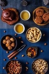 Fototapeta premium Food themed still life with crockery, various nuts and tea. Flat lay. Top view.