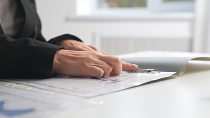 Hands holding a spring loaded folder with documents on an office desk.