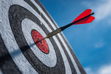 Red dart hitting the bullseye on target