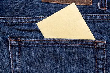 A blank note paper tucked in the back pocket of a pair of blue jeans, suggesting organization and casual style. Ideal for concepts like reminders or personal notes.