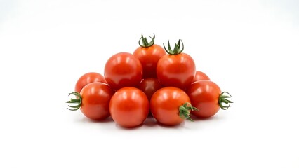 Small pile of fresh ripe red cherry tomatoes with green stems rests on a clean bright white background studio shot
