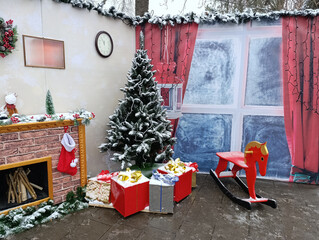 Cozy Christmas interior with a Christmas tree, gifts, a cute wooden rocking horse in a red color.