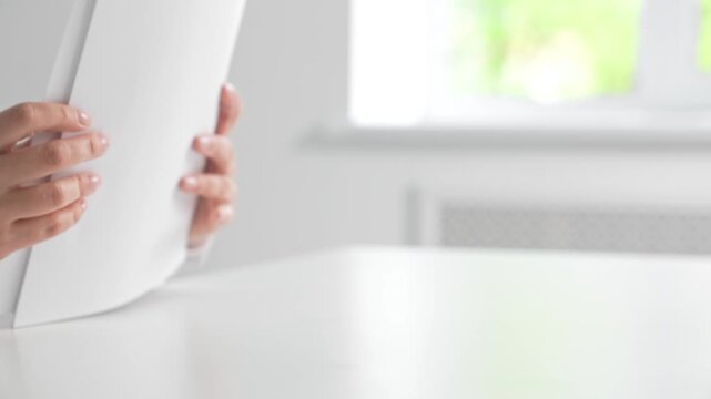 Person in White Shirt Holding a Thick Stack of Papers