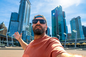 Tourist taking selfie with vancouver skyline in background