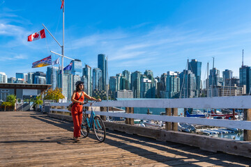 Tourist walking with bicycle on pier in vancouver, british columbia