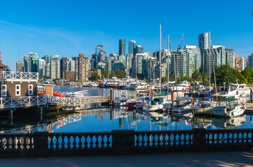 Obraz premium Vancouver skyline reflecting in coal harbour on a sunny day