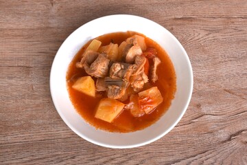 fried mixed vegetable with chop pork bone in sweet and sour gravy sauce on plate 