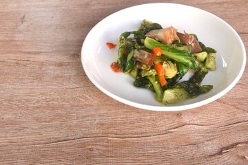 fried Brussels sprout or baby cabbage and crispy pork with soy sauce on plate 